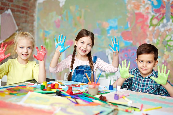 children painting with hands up covered in paint